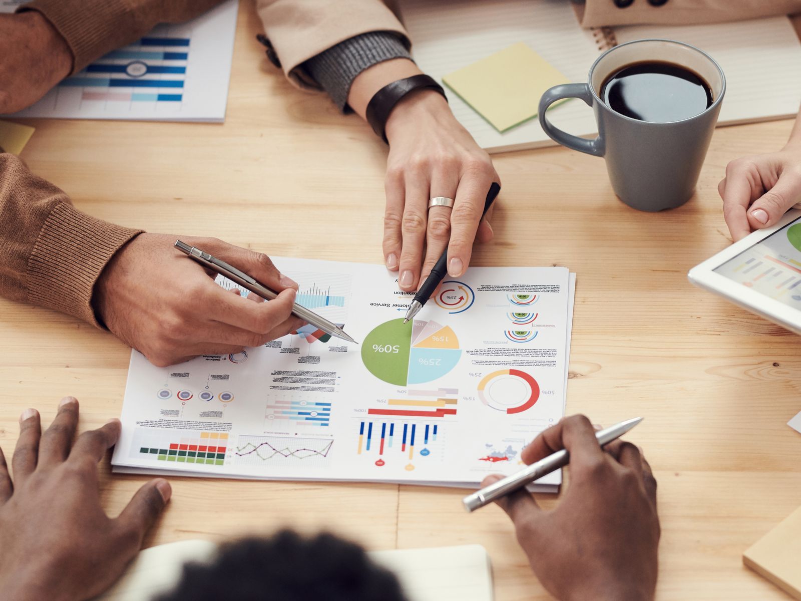 Personas revisando un reporte de métricas con gráficas sobre una mesa